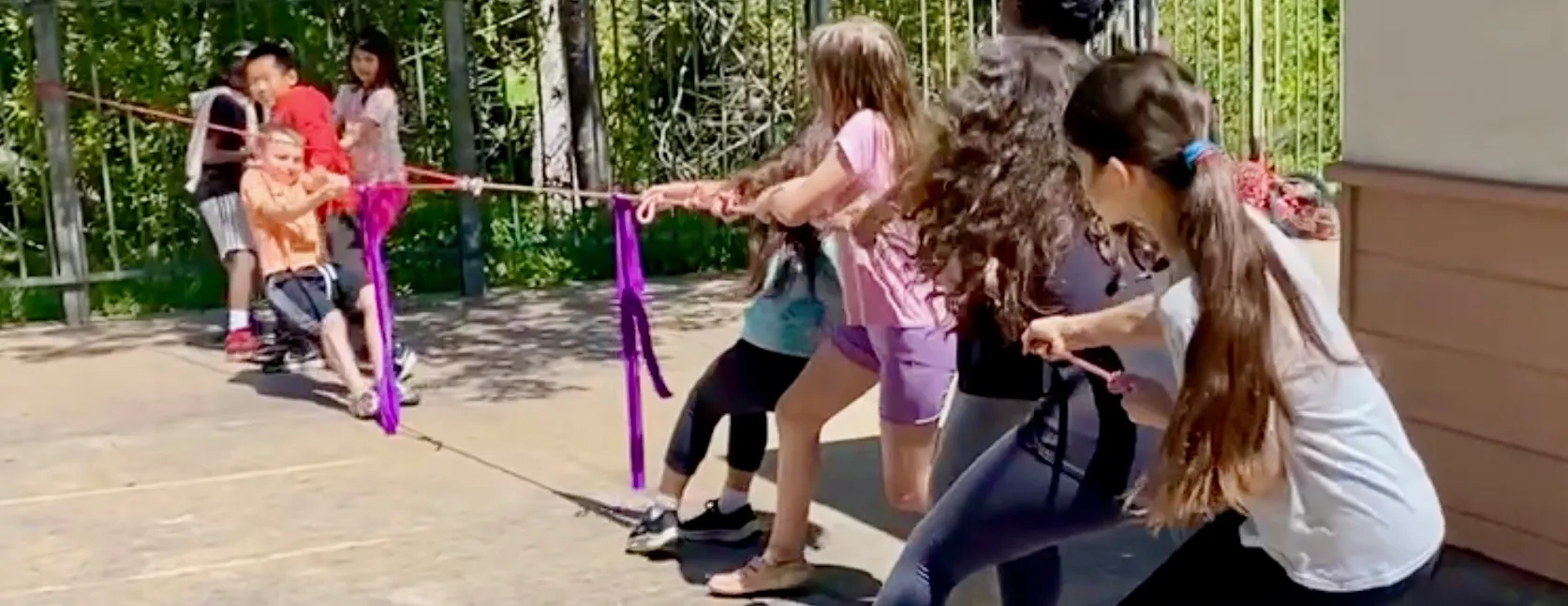 Elementary kids challenge middle-school kids in a round of Pulley-Tug-of-War.